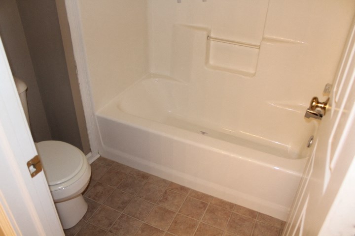 a bathroom with a white tub and a toilet