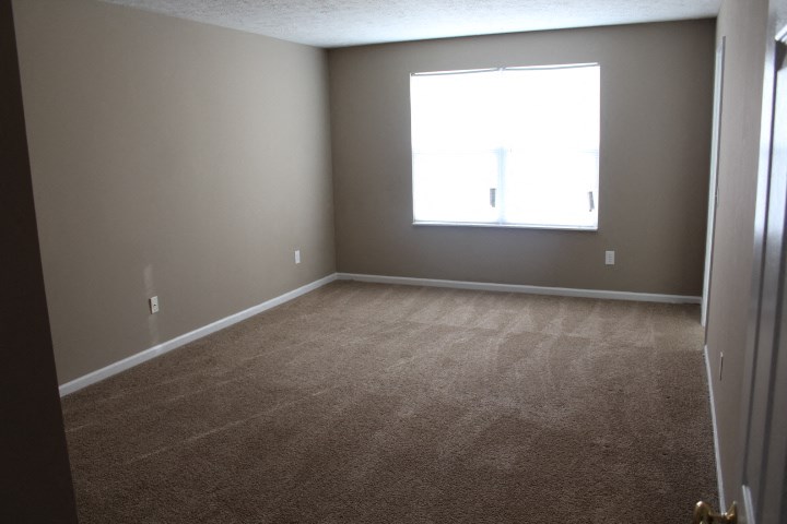 an empty room with carpet and a window