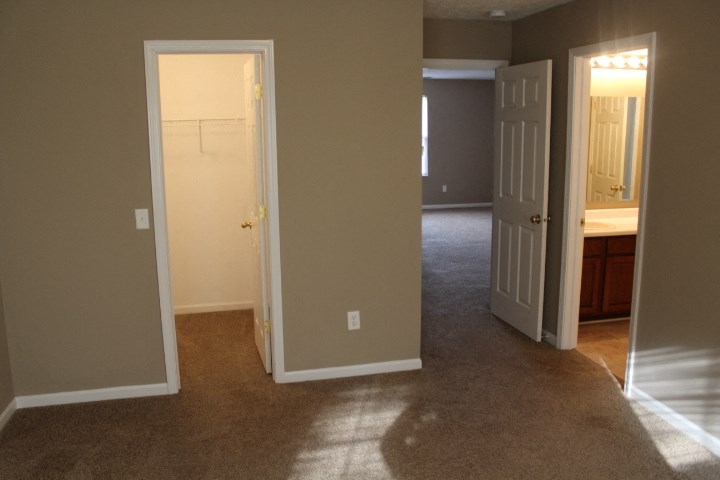 an empty living room with a door open to a bathroom