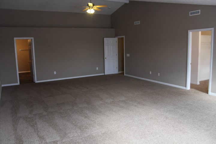 a empty living room with a ceiling fan