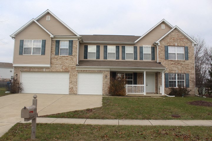 a house with two garage doors and a sidewalk in front of it