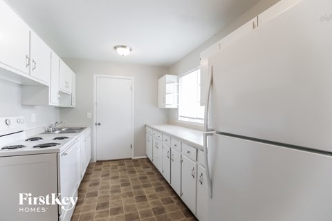 a white kitchen with white appliances and white cabinets