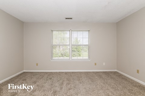 a bedroom with carpet and a window
