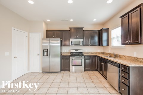 A kitchen with a stove top oven and a refrigerator.