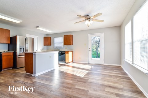 an empty kitchen and living room with a ceiling fan