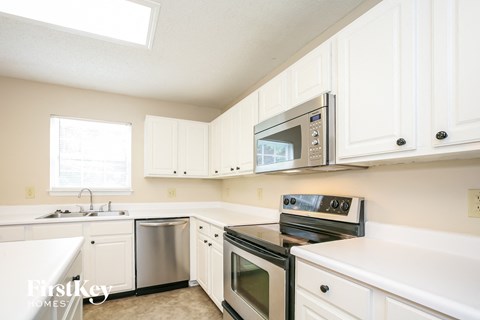 a kitchen with white cabinets and stainless steel appliances