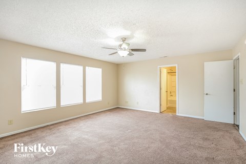 a living room with carpet and a ceiling fan