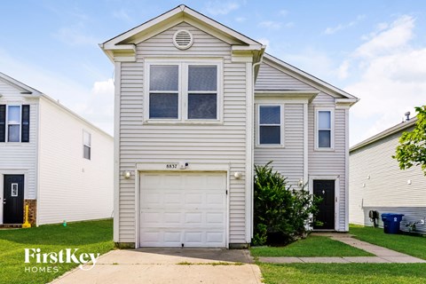 A two-story house with a garage is for sale.
