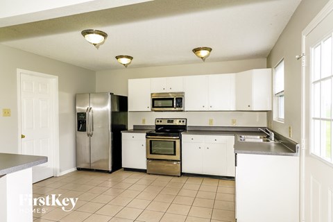 A kitchen with white cabinets and a stainless steel refrigerator.