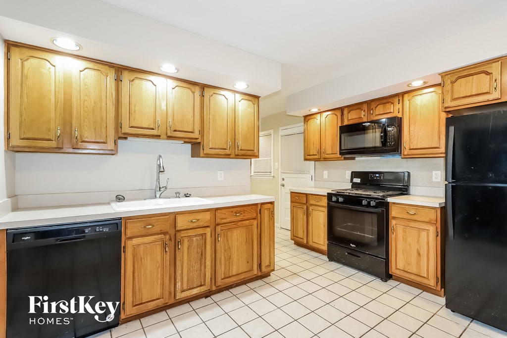 a kitchen with wooden cabinets and black appliances
