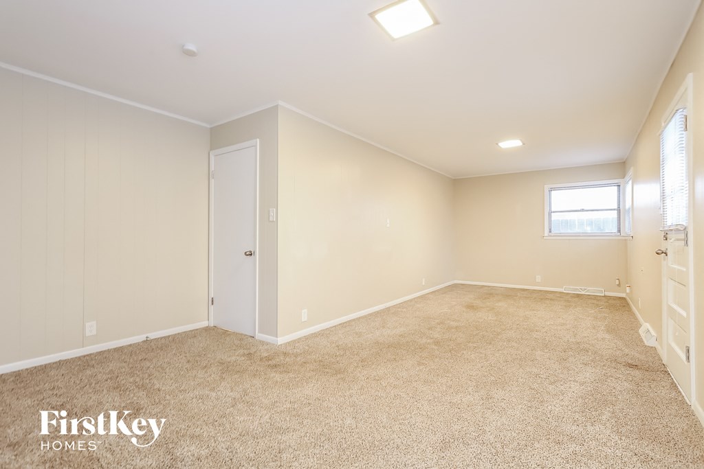a bedroom with carpet and a closet and a window