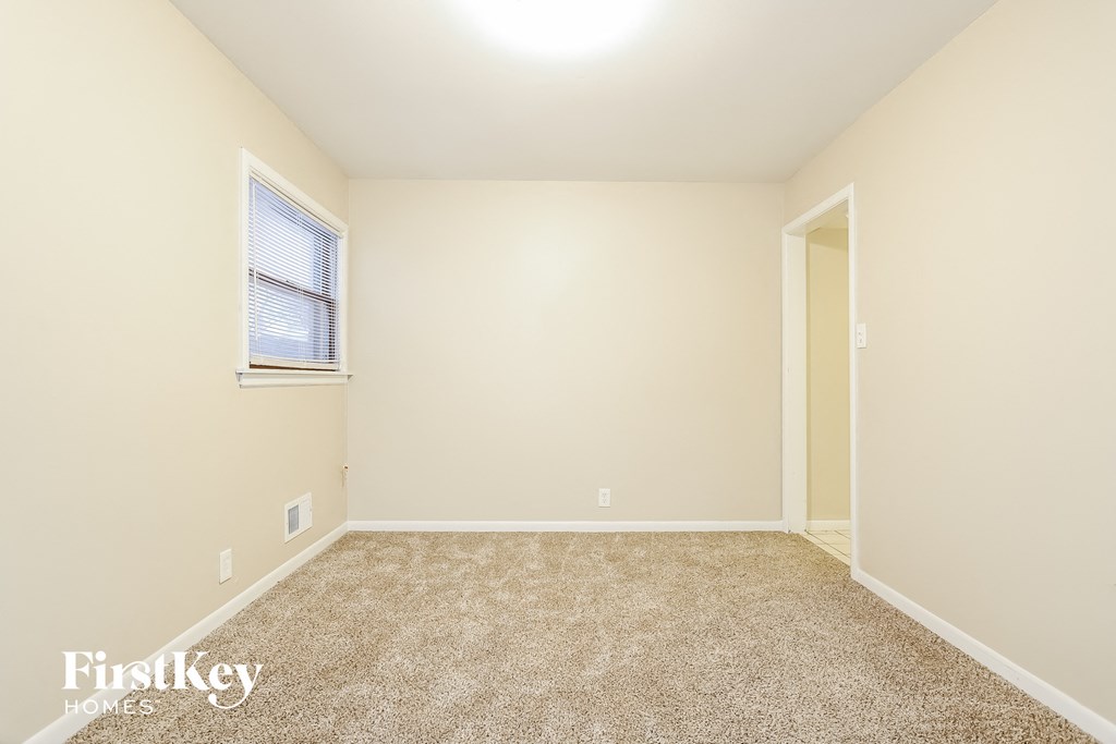 a spacious room with carpet and a window