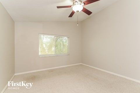 a bedroom with a ceiling fan and a window