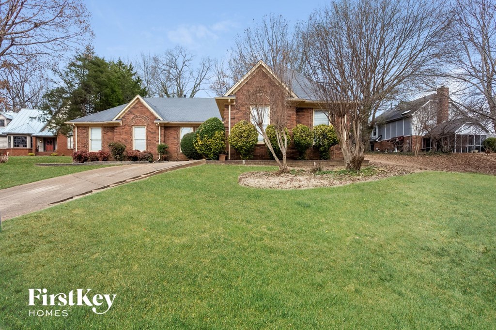 A brick house with a green lawn in front.