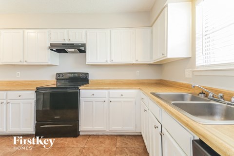 a kitchen with white cabinets and a black dishwasher