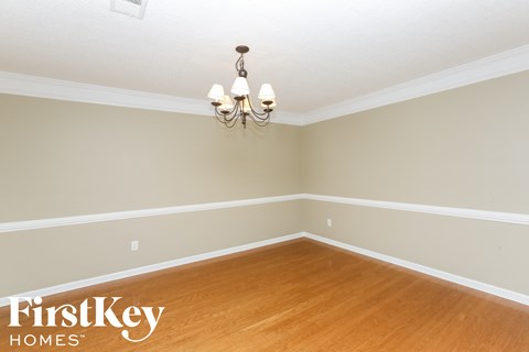 A room with wooden floors and a chandelier hanging from the ceiling.