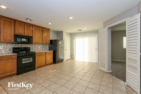A kitchen with wooden cabinets and black appliances.