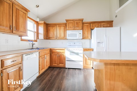 A kitchen with wooden cabinets and white appliances.