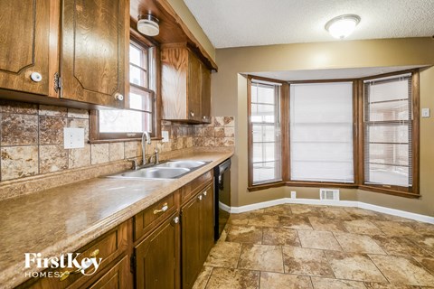 A kitchen with wooden cabinets and a marble countertop.