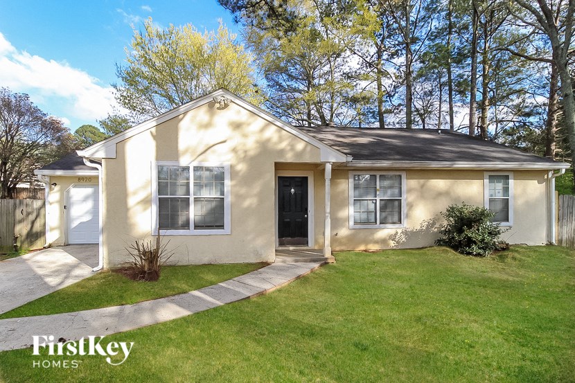 the front of a house with a lawn and a sidewalk