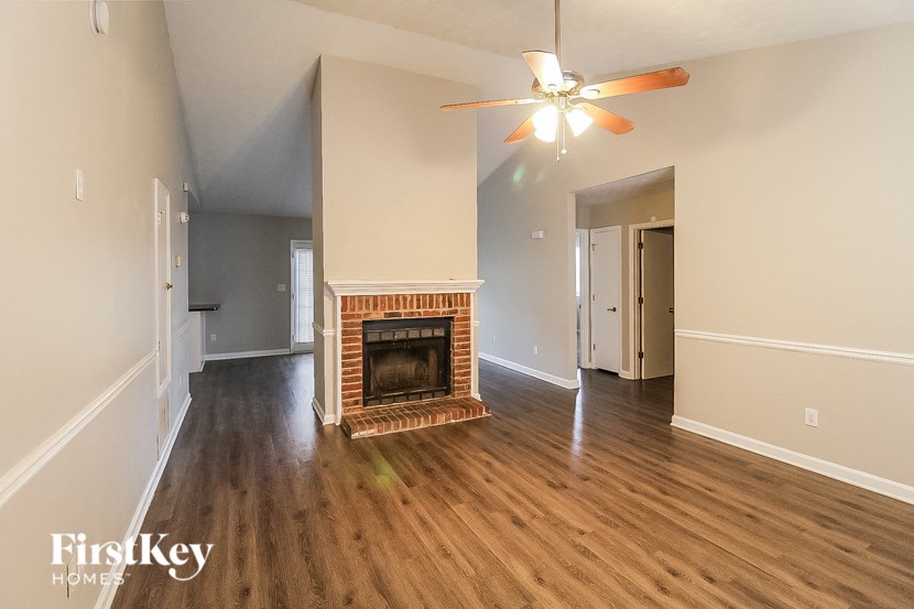 a living room with a fireplace and a ceiling fan