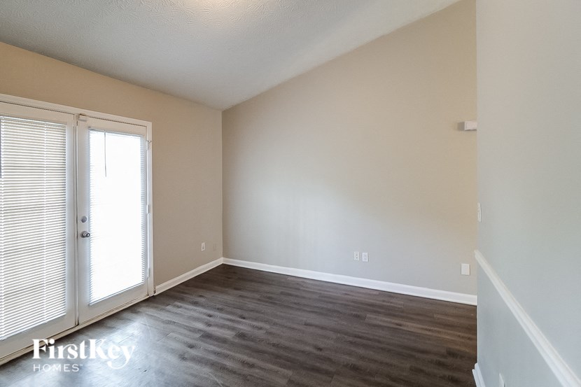 an empty living room with wood flooring and white walls