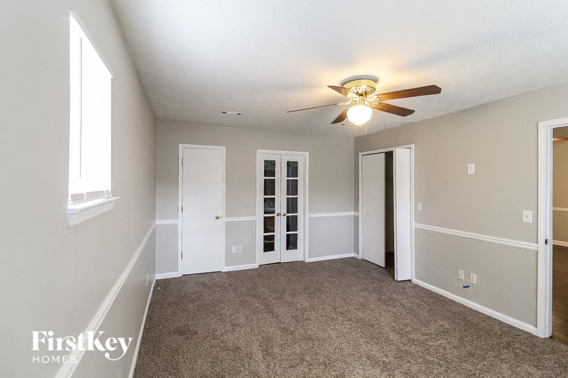 a living room with carpet and a ceiling fan