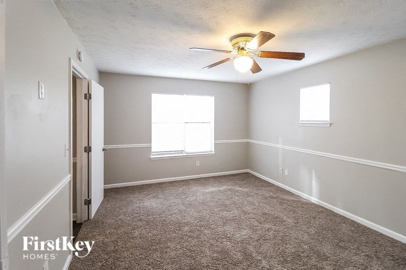 a bedroom with carpet and a ceiling fan