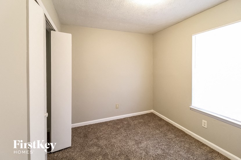 an empty room with carpet and a window