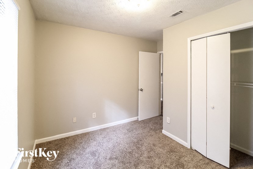 a bedroom with a closet and a mirrored closet door