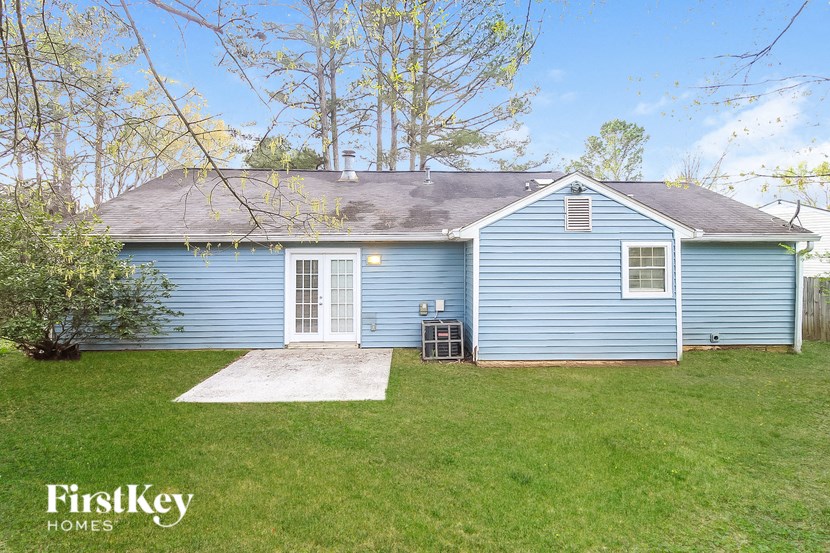 the front of a blue house with a yard and grass