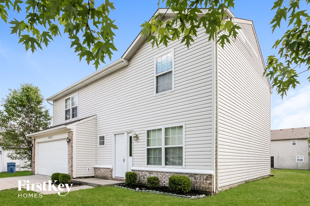 a white house with white siding and a white garage door
