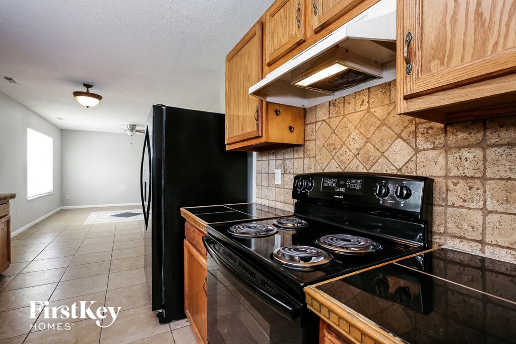 a kitchen with black appliances and wood cabinets
