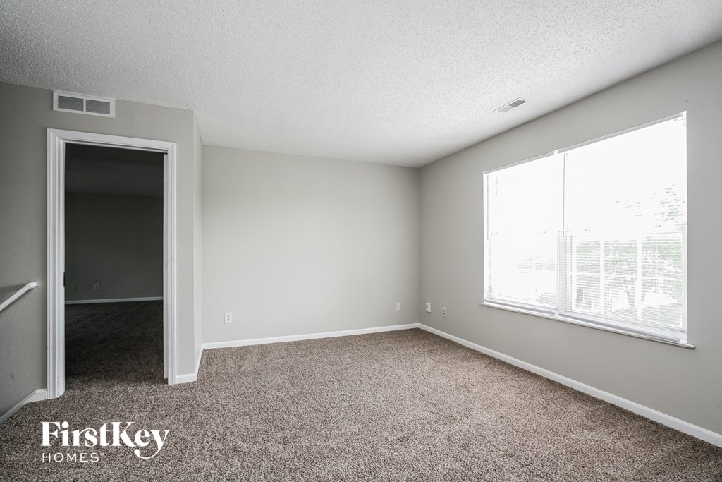 a bedroom with a carpeted floor and a large window