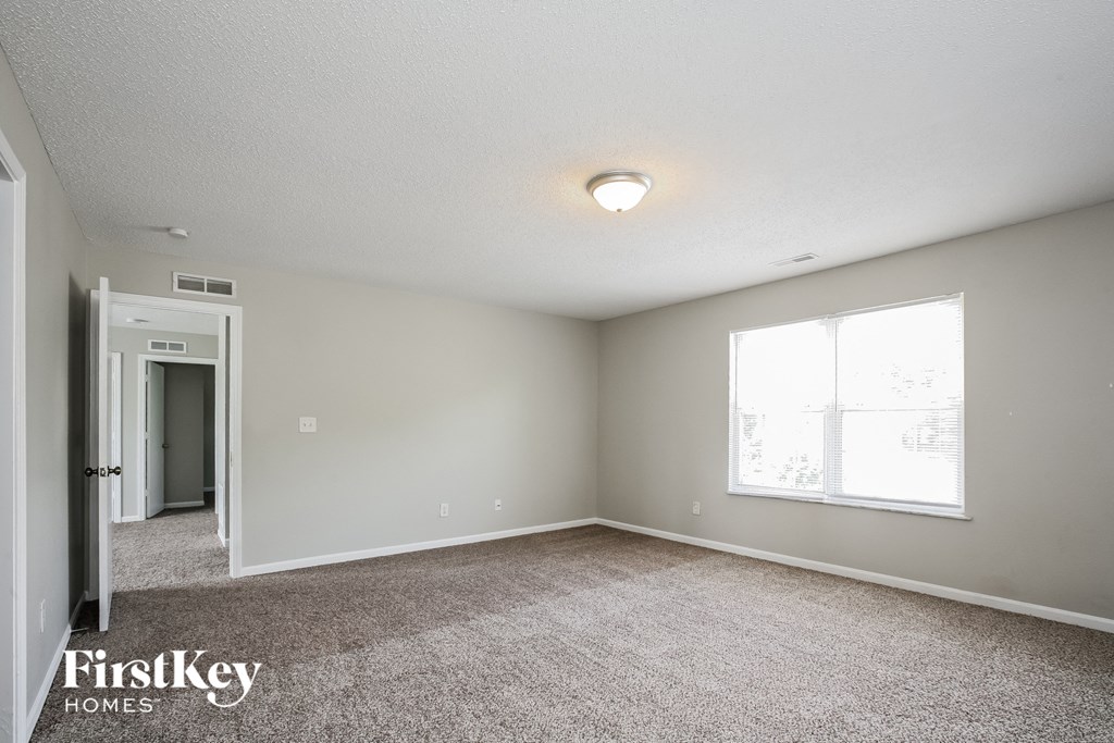 the spacious living room with carpeting and a large window