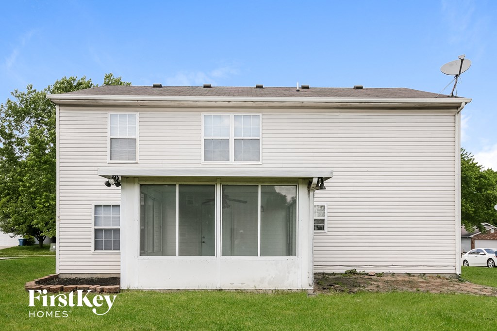 the front of a white house with a satellite dish on the roof