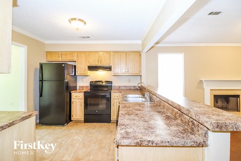 A kitchen with a granite counter top and a fireplace.