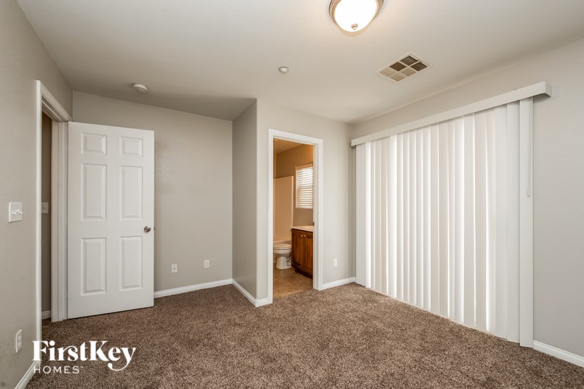A spacious room with a carpeted floor and a sliding door.