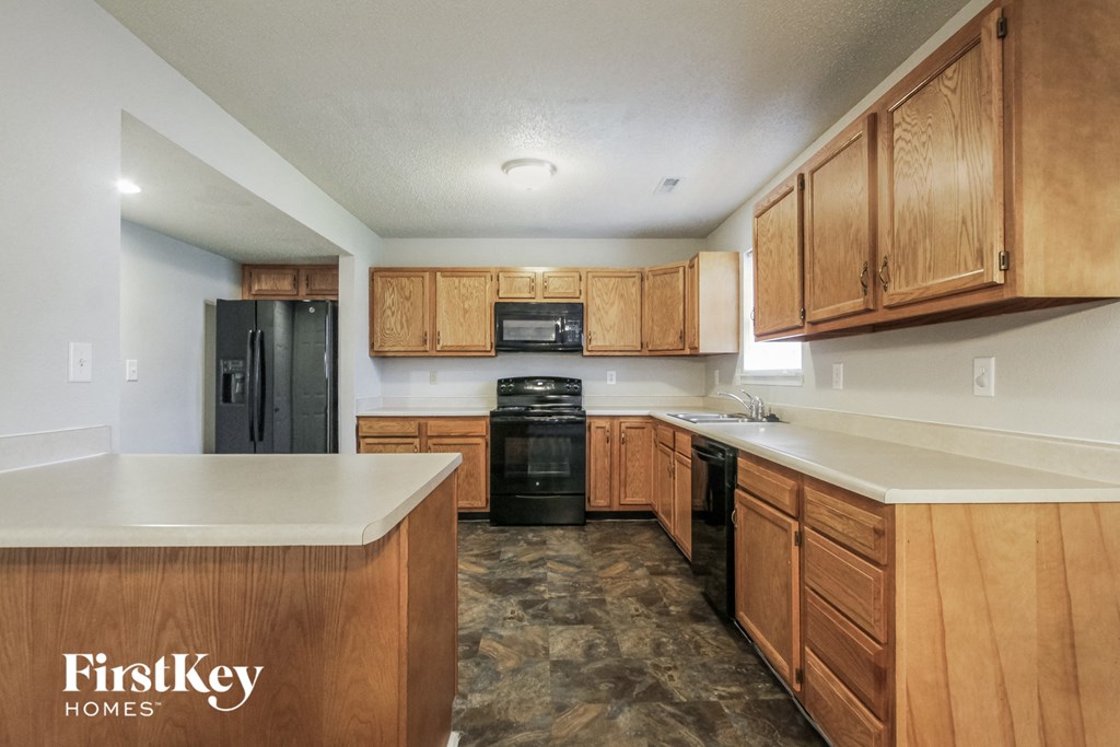 A kitchen with wooden cabinets and a FirstKey Homes logo.