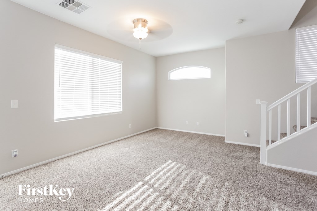 an empty room with a staircase and a window