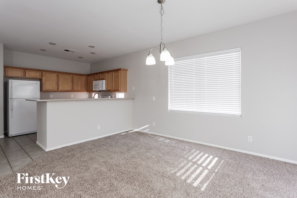 a kitchen and living room with a carpeted floor