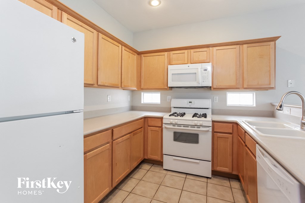 a kitchen with white appliances and wooden cabinets