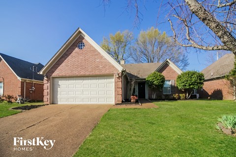 a house with a white garage door in front of a lawn