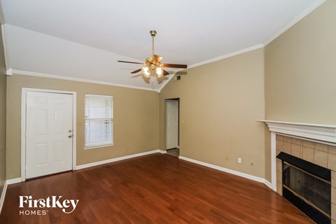a living room with a fireplace and a ceiling fan