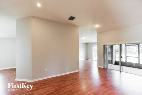 a living room with a hard wood floor and a glass door