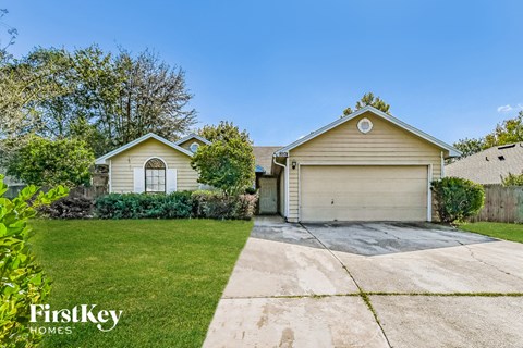 a yellow house with a driveway and a garage door