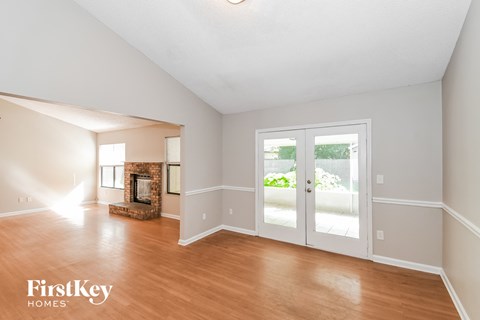 the living room and dining room with wood floors and doors