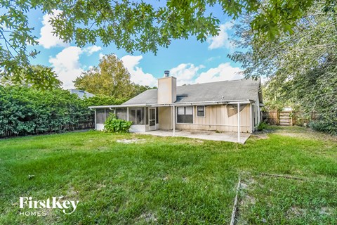 a backyard with a house and a grassy yard