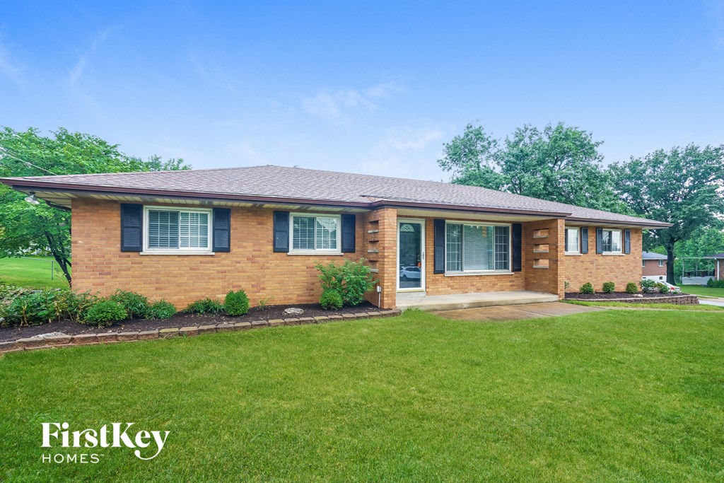 A brick house with a green lawn in front.