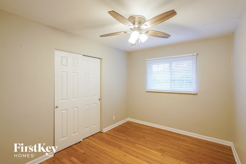 A room with a ceiling fan and a door.
